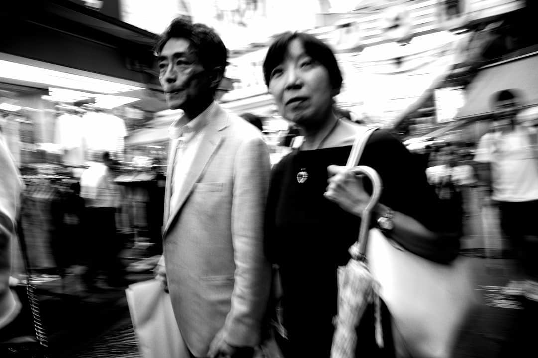 Two people moving through a market street