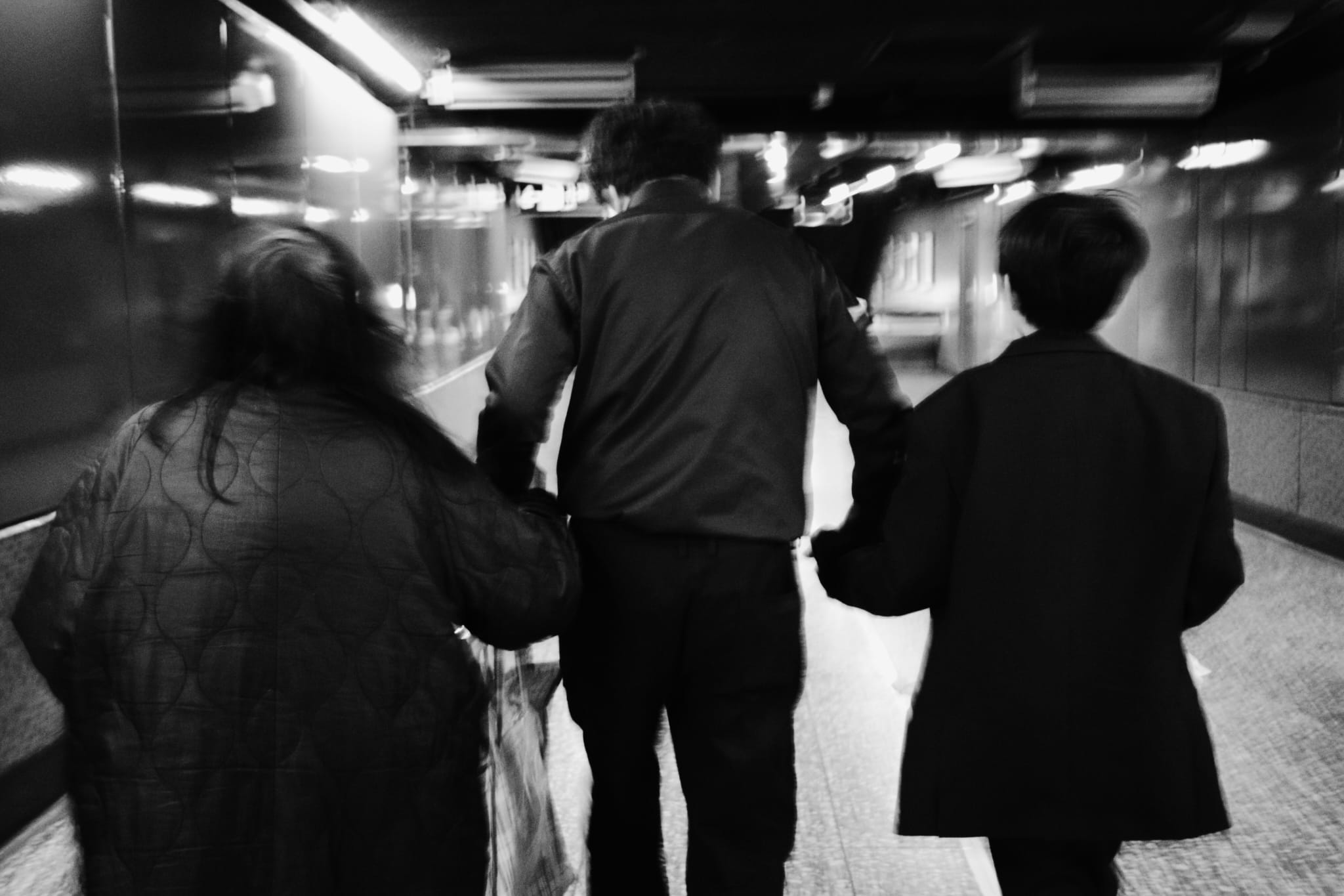 Three people walking through an underground passage