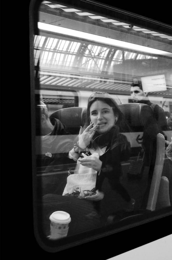 A woman seated beside a train window