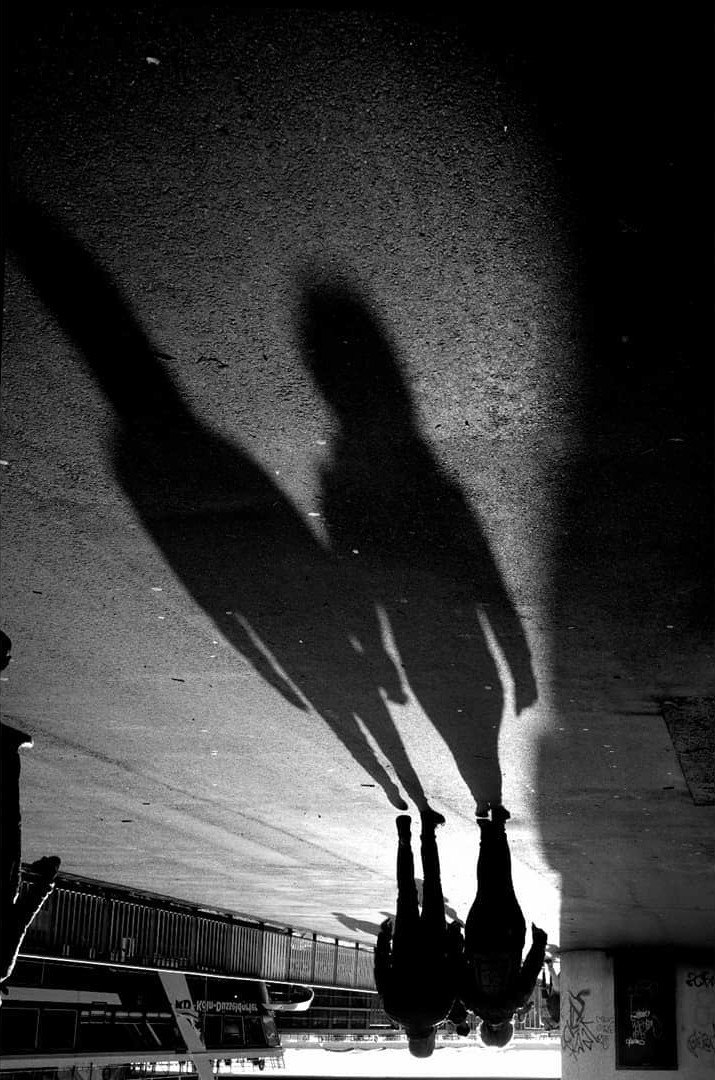 Long pedestrian shadows on a pavement