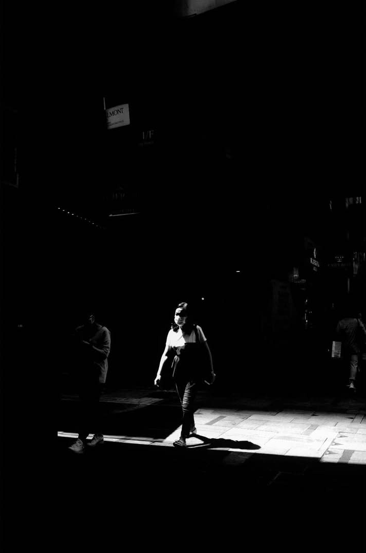 A solitary figure entering a shaft of light