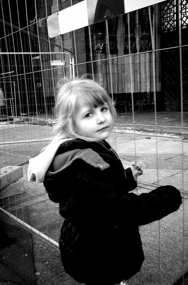 A child sitting beside a glass wall