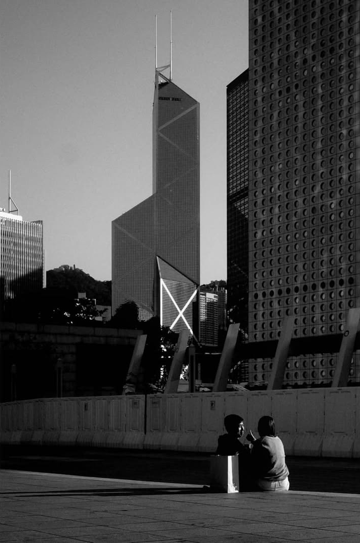 A person standing beneath angular urban architecture