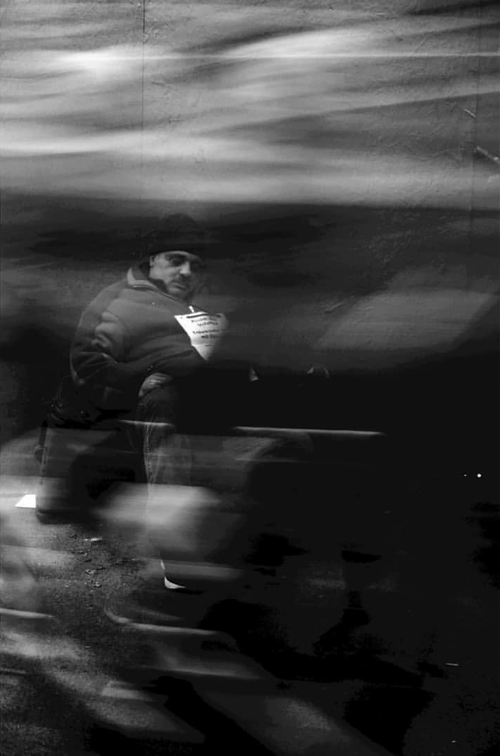 A blurred pedestrian crossing a dark frame
