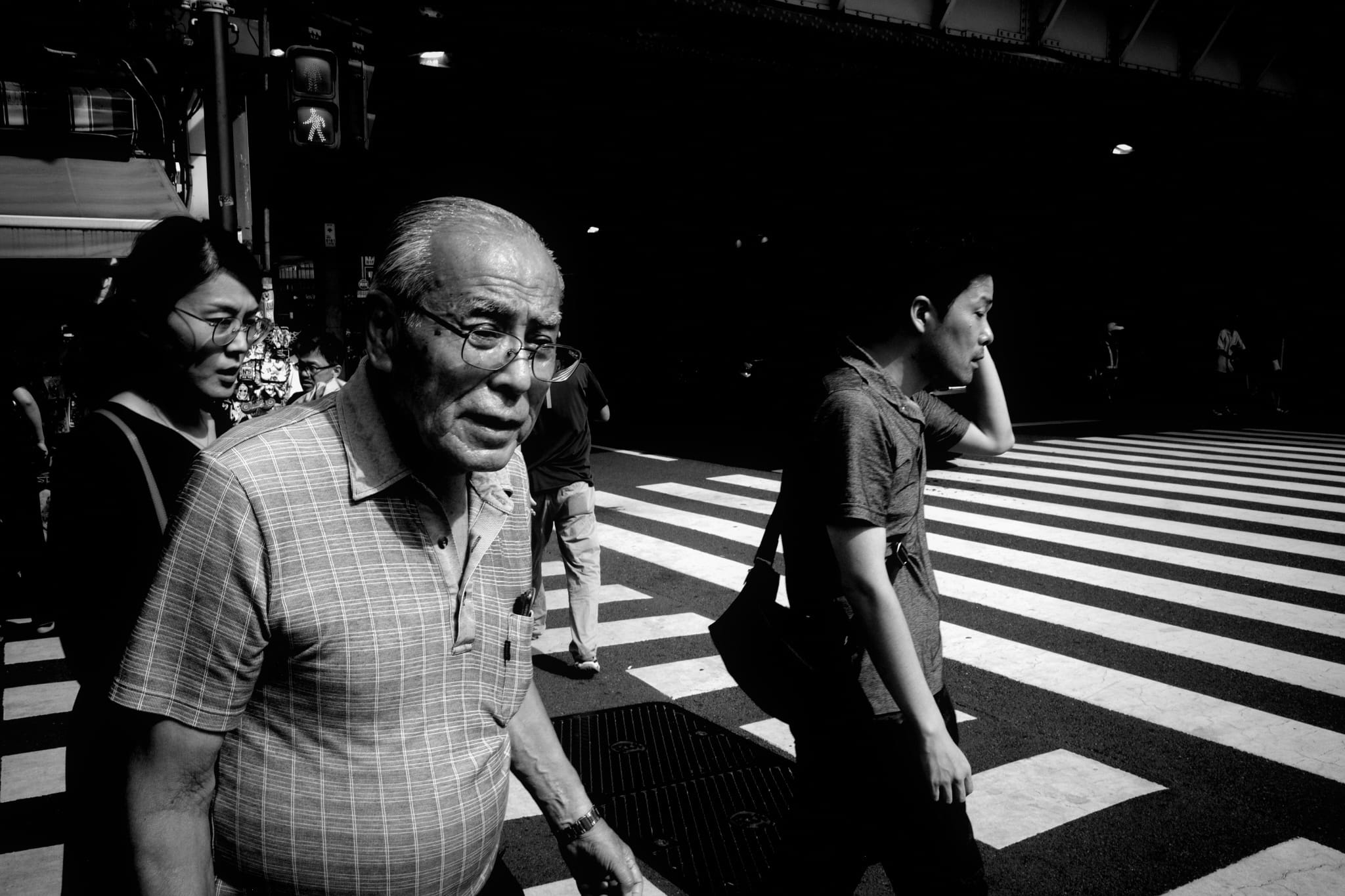 An older man crossing a striped intersection