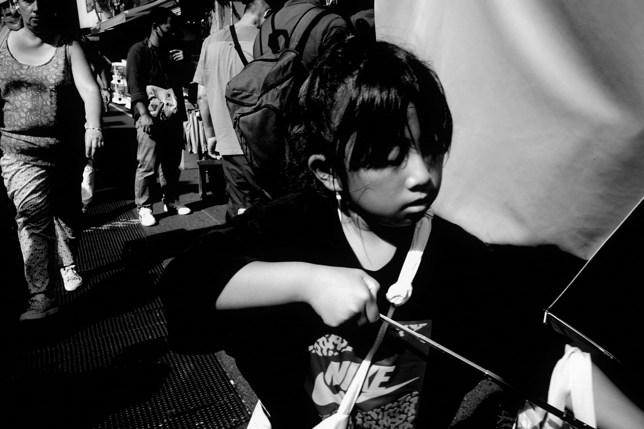 A child sitting quietly in a crowded street